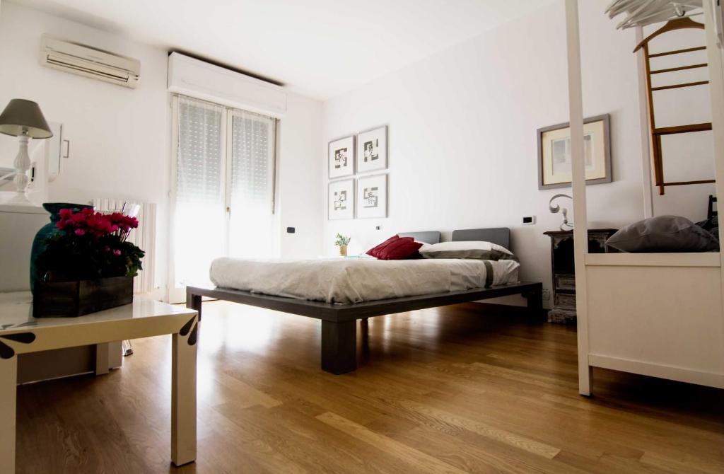 My b&b - Strada Vecchia del Pinocchio 3/B في أنكونا: غرفة نوم بيضاء مع سرير وأرضية خشبية