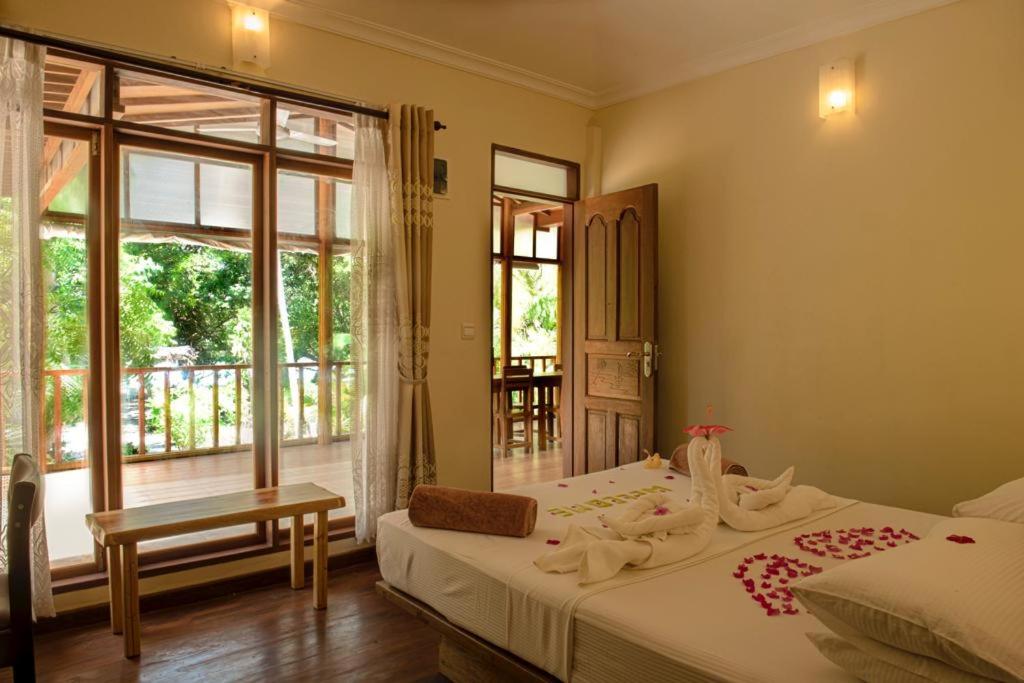 Hangnaameedhoo的住宿－繞道海灘景旅館，一间卧室设有一张床和一个大窗户