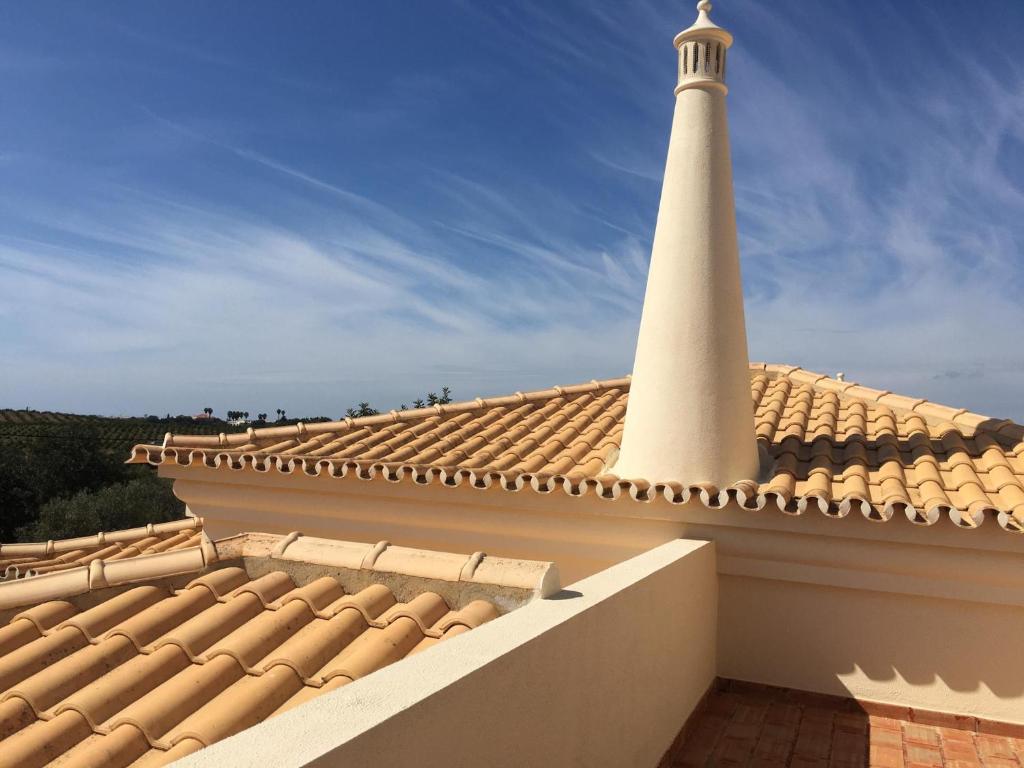 a lighthouse on the roof of a building at Casa Alfazema - Villa Algarvia de Charme in Pechão