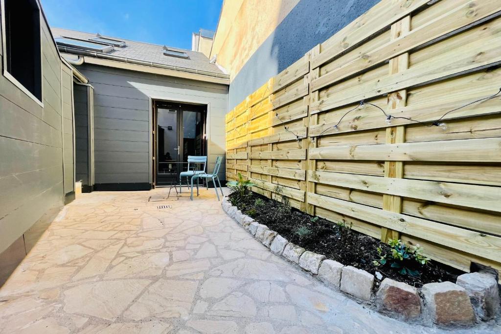 a wooden fence next to a house with a patio at The EDGARD Cocoon in the heart of Les Halles in Tours