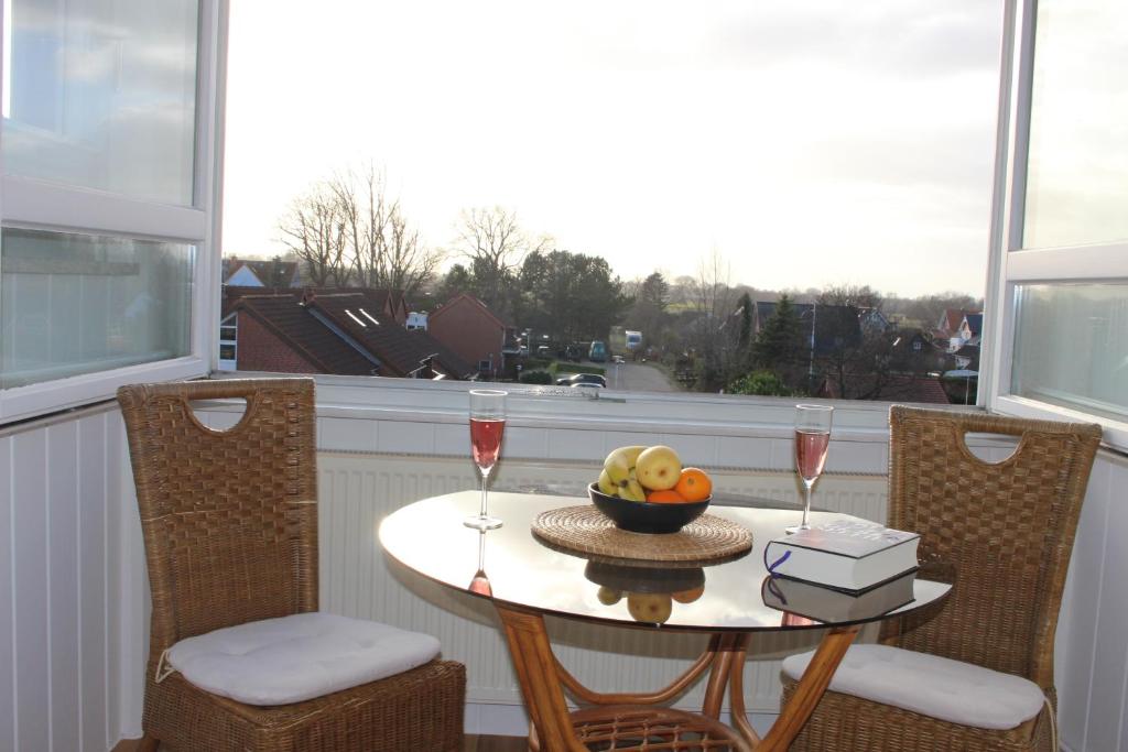 einen Tisch mit einer Schale Obst und zwei Gläsern Wein in der Unterkunft Ferienwohnung Ostseeglück, Schönberger Strand, Meerblick in Stakendorfer Strand