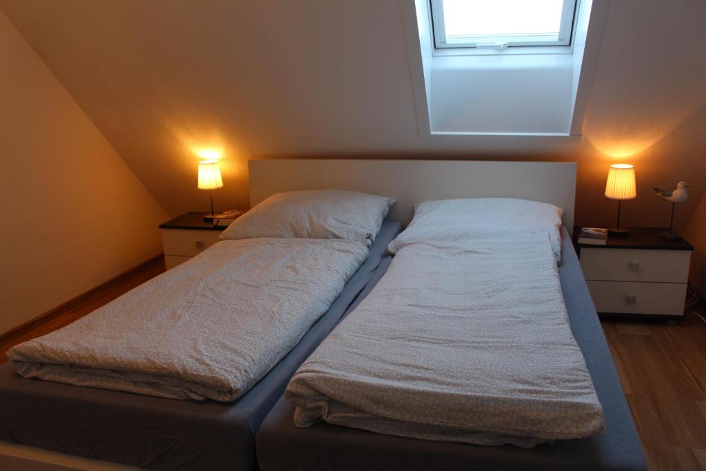 ein großes Bett in einem Zimmer mit zwei Lampen in der Unterkunft Ferienwohnung Ostseeglück, Schönberger Strand, Meerblick in Stakendorfer Strand