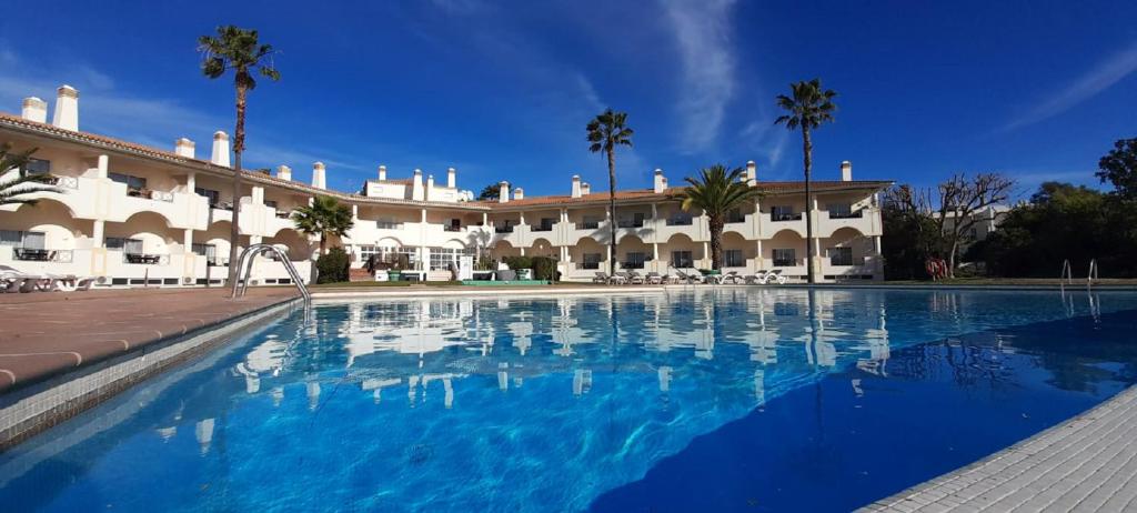 une grande piscine en face d'un bâtiment dans l'établissement Colina Verde Resort, à Moncarapacho