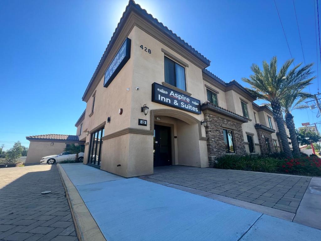 a building with a sign on the front of it at ASPIRE INN & SUITES Orange in Orange