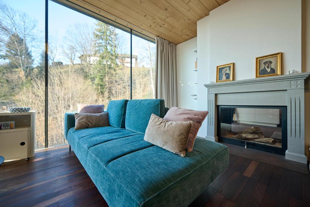 un sofá azul en una sala de estar con chimenea en Design Apartment mit Naturblick en Bregenz