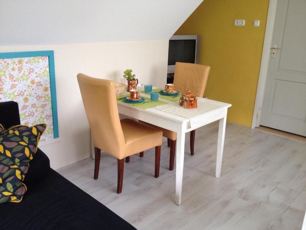 een witte eettafel en stoelen in een kamer bij B&B de Kornelishoeve in Drouwen