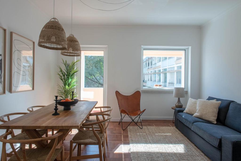 a living room with a blue couch and a table at Inesquecível estadia na praia de Carcavelos in Carcavelos