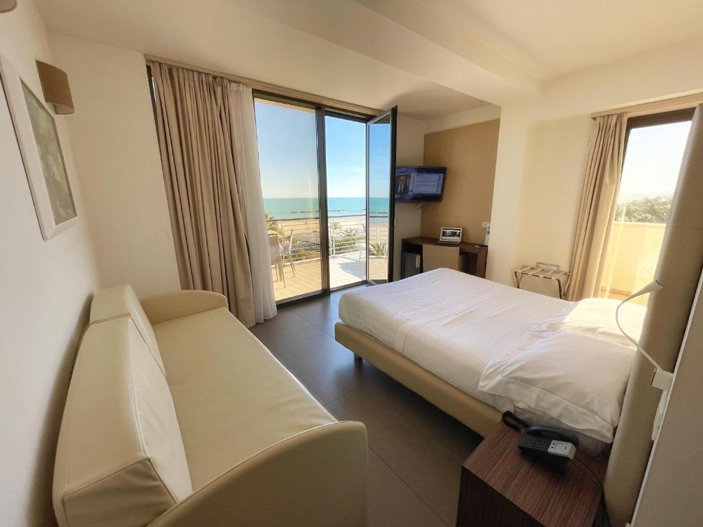 a hotel room with a bed and a view of the ocean at Hotel Arlecchino in San Benedetto del Tronto