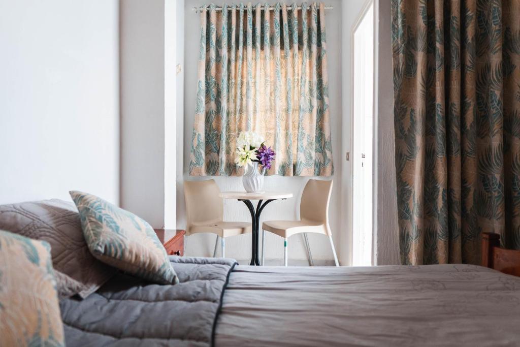 蘇塞的住宿－Hôtel Résidence Monia，一间卧室配有一张床和一张桌子及椅子
