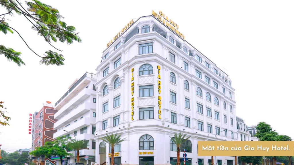 Gia Huy Hotel في Ðông Khê: مبنى ابيض عليه لافته جانبيه