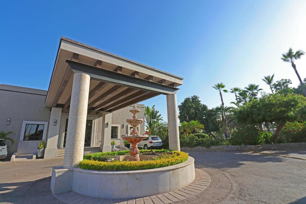 a fountain in a circle in front of a building at Hotel Del Rio in Navojoa