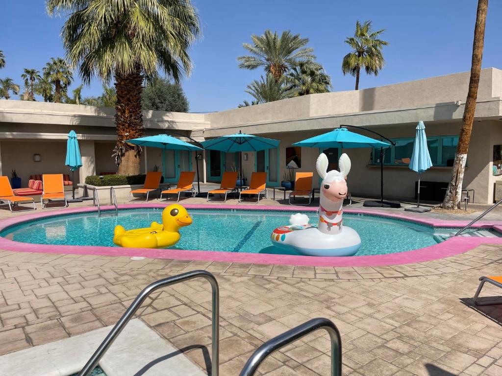 een zwembad in een resort met een speelgoedkonijn en een opblaasbare bij El Noa Noa in Palm Springs