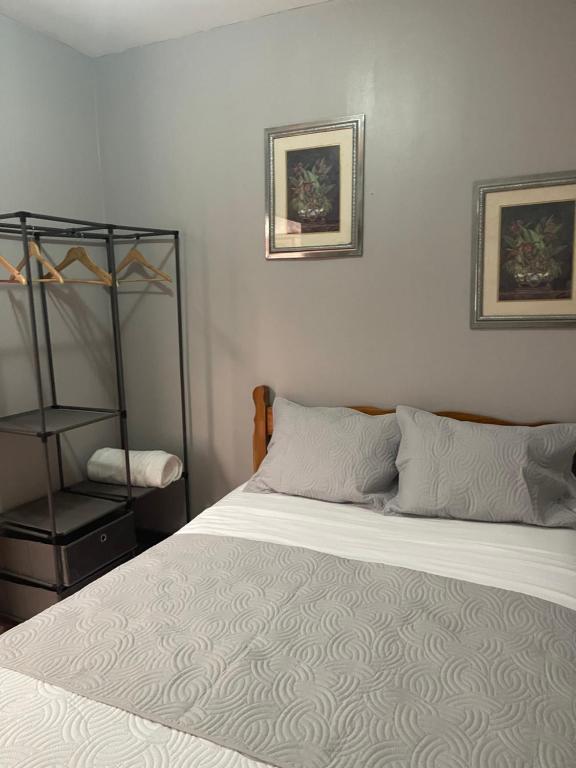 a bedroom with a white bed and a chair at Relax In Downtown Alajuela 5 min Near The Airport in Alajuela