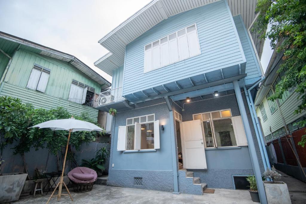 a blue house with an umbrella in front of it at Dara Three Hostel ดาราตรี in Bangkok