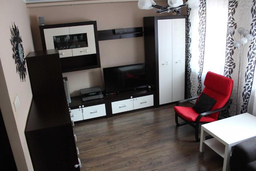 a living room with a television and a red chair at Luxury apartaments Klimatyzacja 2 in Radom