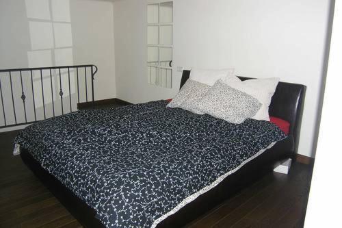 ブダペストにあるSushi Apartmanのベッドルーム(枕付きの黒と白のベッド1台付)