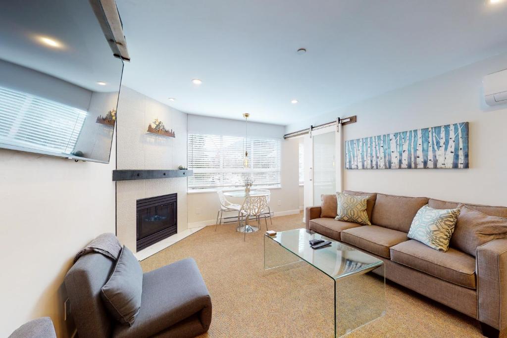 a living room with a couch and a fireplace at Market Place Lodge 249 in Whistler