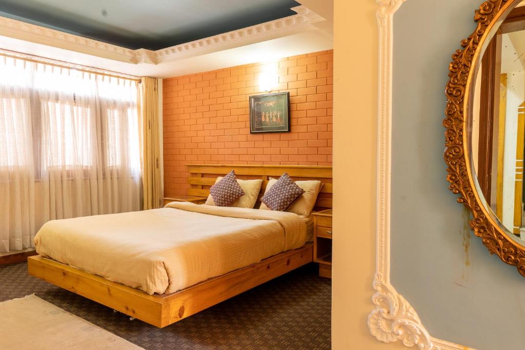 a bedroom with a bed and a mirror at Times Square Apartments in Pātan