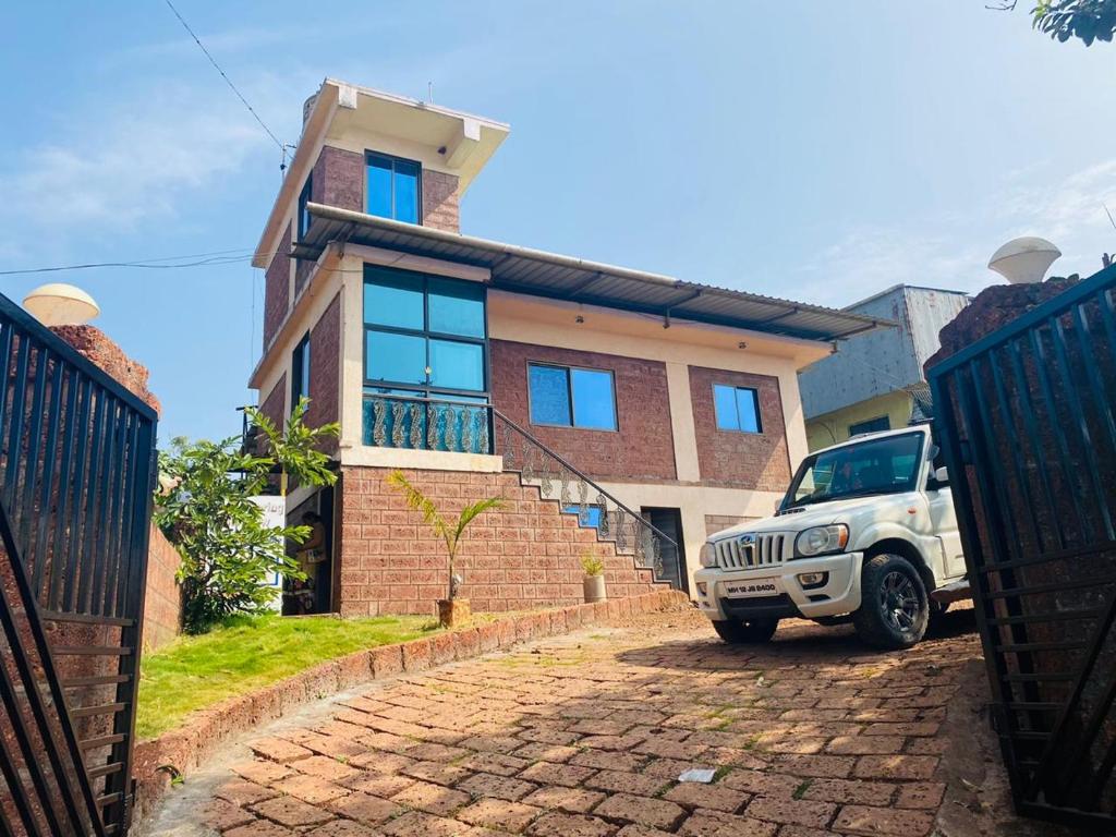 a white jeep parked in front of a house at Golden Spring Villa in Mahabaleshwar