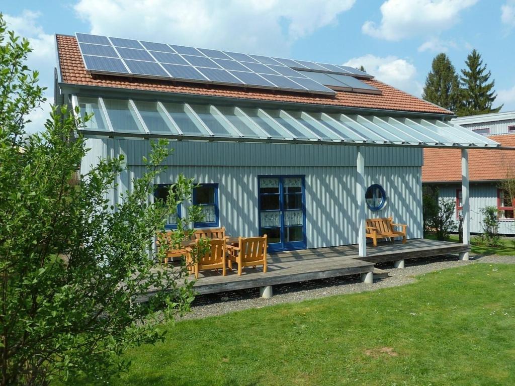Ferienhaus Nr 5C plus, Feriendorf Hagbügerl, Bayr Wald في فالدمونشن: منزل على السطح مع لوحات شمسية
