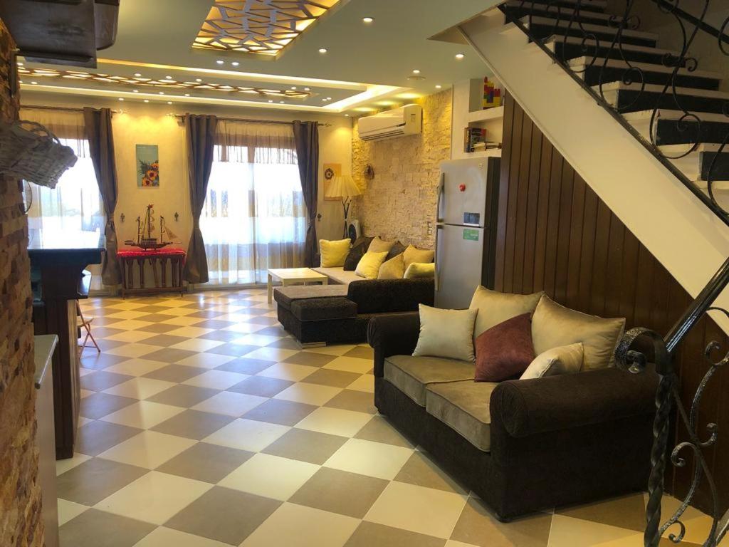 uma grande sala de estar com sofás e uma escadaria em New Panorama Sea View Villa Family em Ain Sokhna