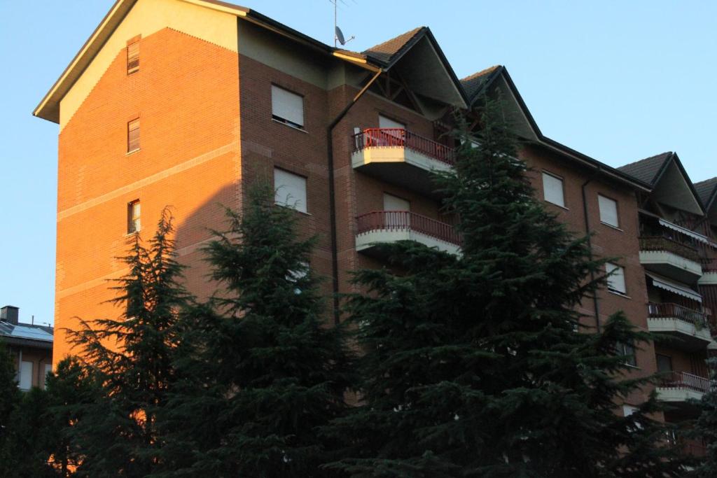 een hoog gebouw met bomen ervoor bij La Mansarda di Legno in Turijn