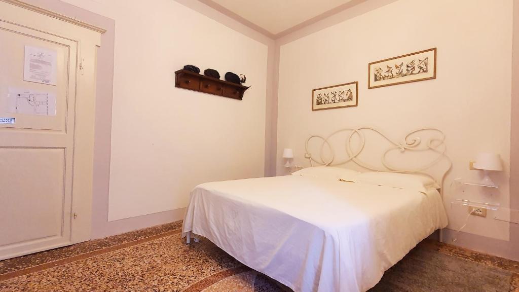 1 dormitorio con 1 cama blanca en una habitación en Relais Pacinotti Rooms, en Pisa