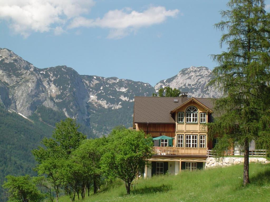 a house on a hill with mountains in the background at Kalßnhof in Bad Aussee