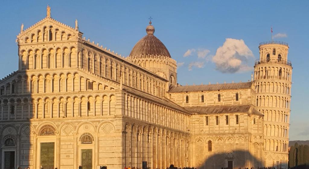 a large building with a tower on top of it at Relais Pacinotti Rooms in Pisa