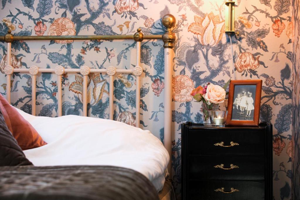 a bedroom with a bed and floral wallpaper at Strandvillan Hotell och Bed & Breakfast in Lysekil