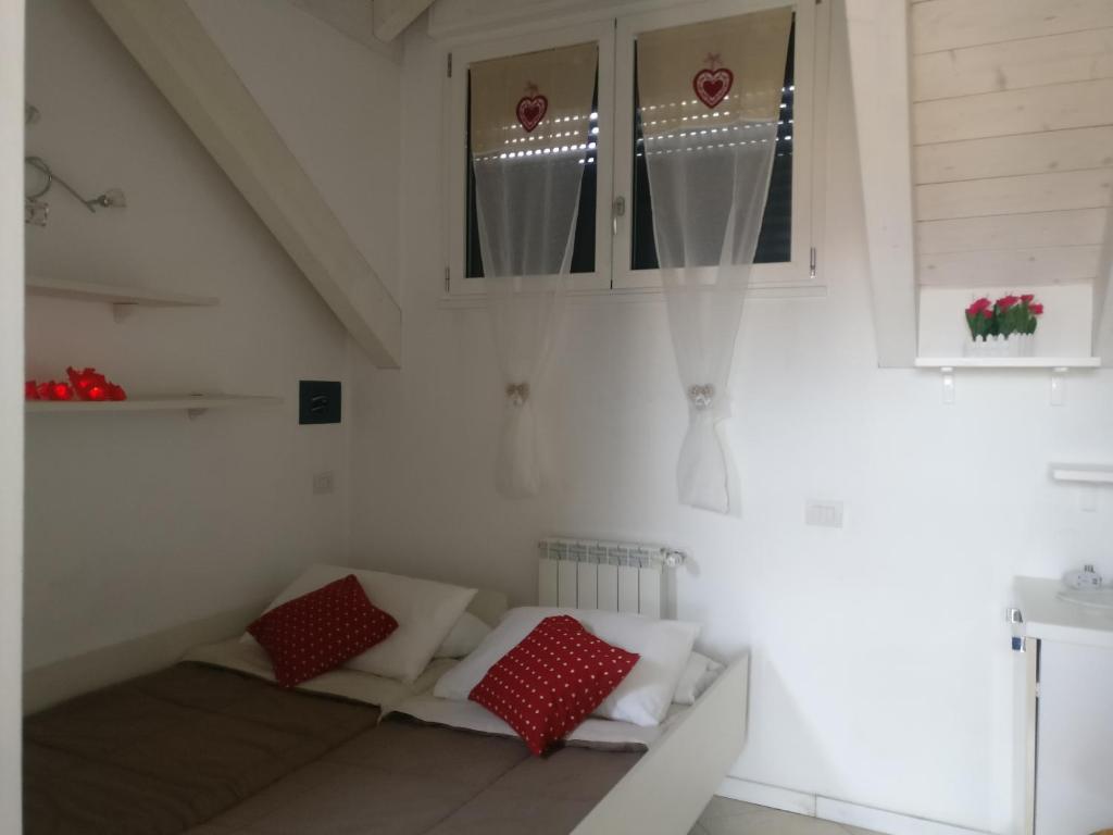 a room with a couch with red and white pillows at Maison Jolie in Rho