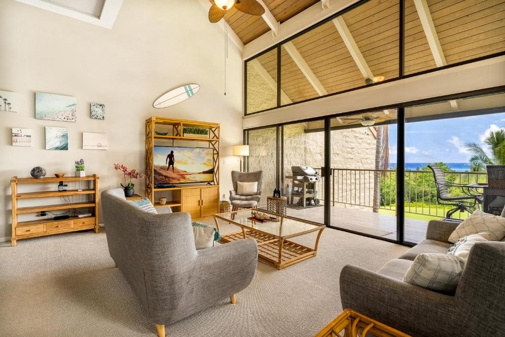 een woonkamer met een bank en stoelen en een televisie bij Keauhou Punahele B301 in Kailua-Kona