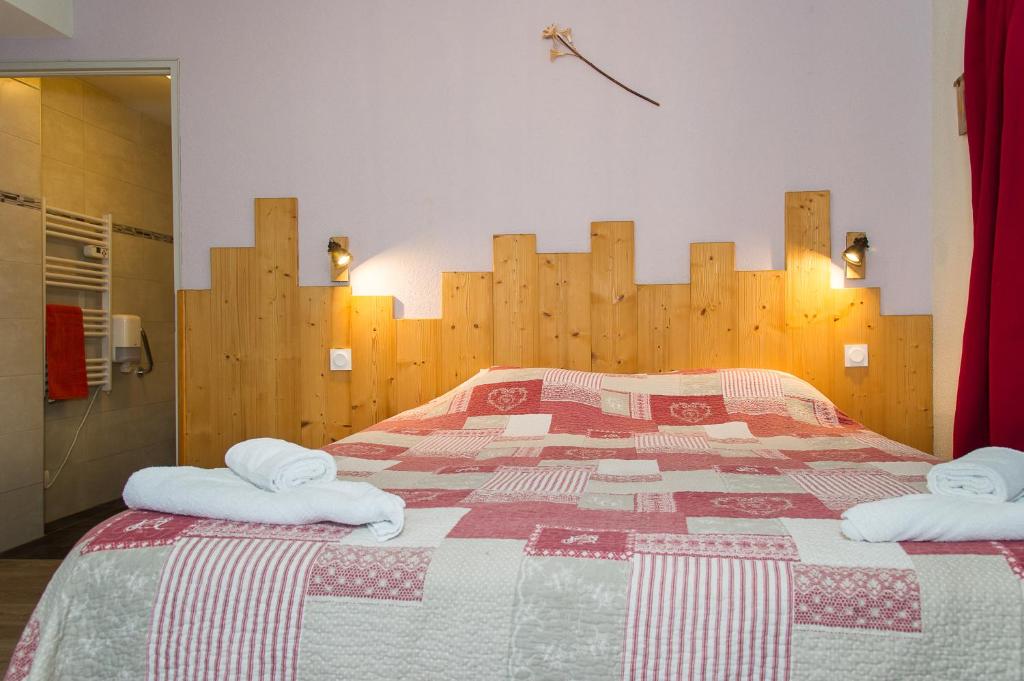 a bedroom with a large bed with towels on it at Gîte Châtel in Châtel