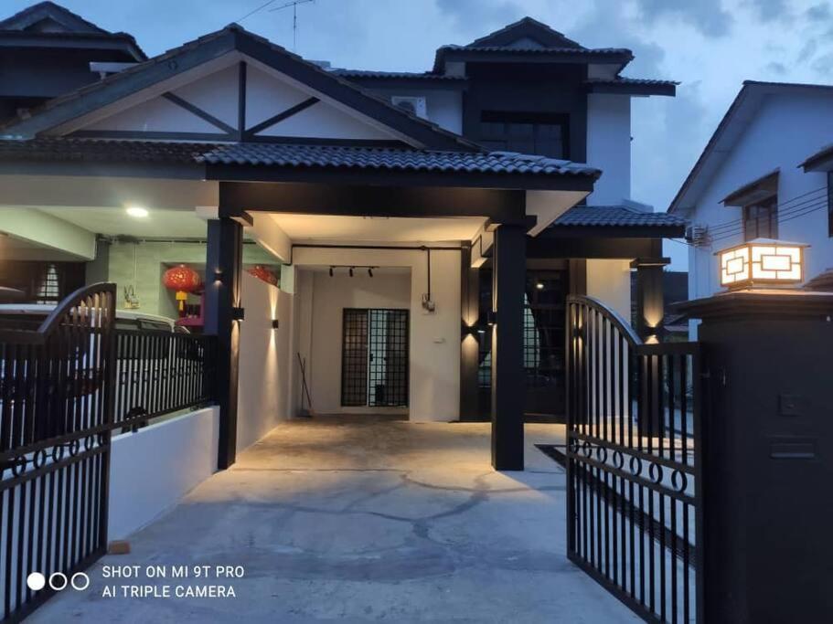a house with a gate and a driveway at 55 homestay 4-bedrooms guesthouse in Bukit Bakri Muar Johor in Bakri