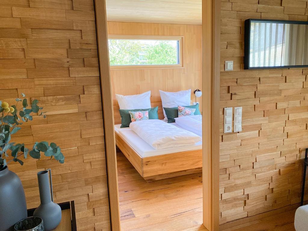 1 dormitorio con 1 cama en una habitación con ventana en Beim Dorfbach I DIE HOFCHALETS en Kressbronn am Bodensee