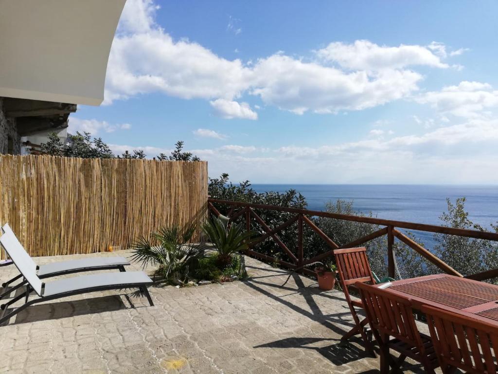 普萊伊亞諾的住宿－Casa Afrodite，一个带桌椅的庭院和大海