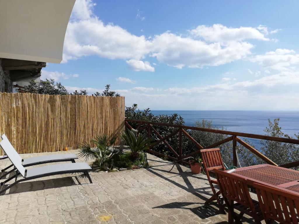 a patio with a table and chairs and the ocean at Casa Afrodite in Praiano
