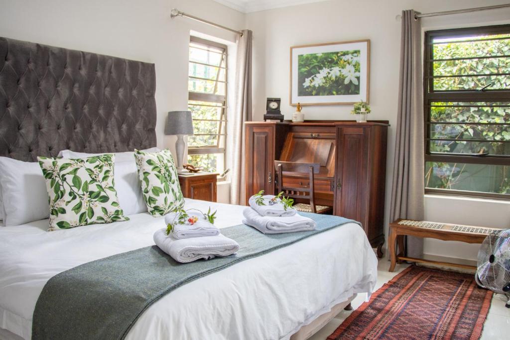 a bedroom with a bed with towels on it at Jasmine Guest Cottage in Benoni