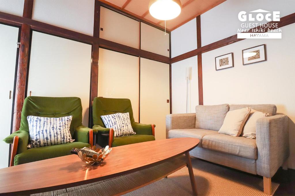uma sala de estar com duas cadeiras e um sofá em GLOCE 葉山 ゲストハウス l 一色海岸のそばでペットと一緒にシーサイドライフ em Hayama