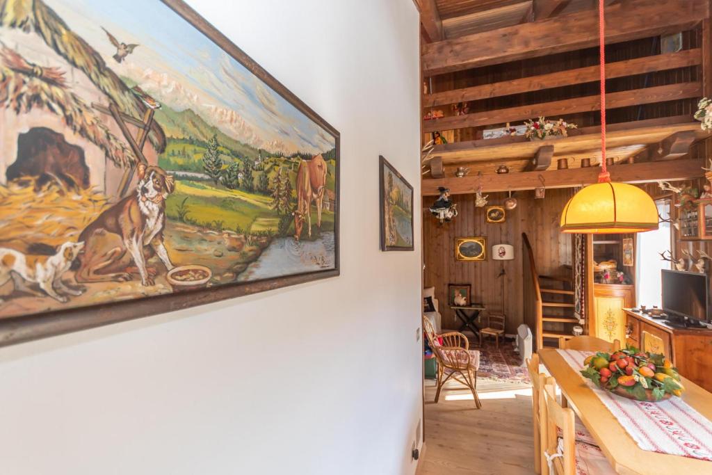 a painting of a dog hanging on a wall in a room at Condominio Pien dal Lat in Selva di Cadore