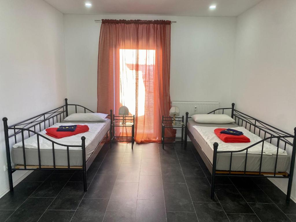 two beds in a room with a window at Pension Kaufungen in Kaufungen