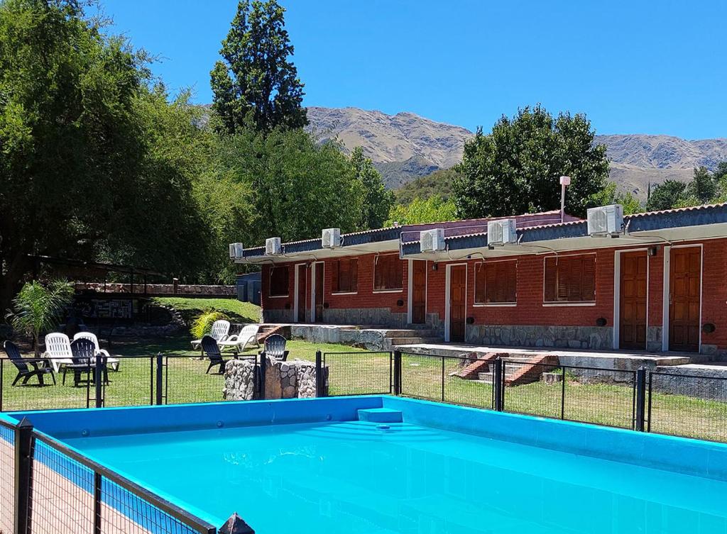 a swimming pool in front of a building at Nuevo Hotel Aguada del Zorro in Merlo