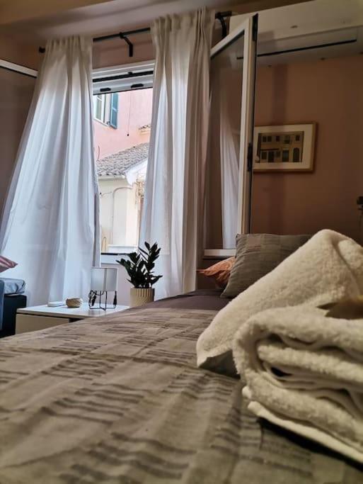 a bedroom with a large bed and a window at Santi Padri Apartment in Corfu