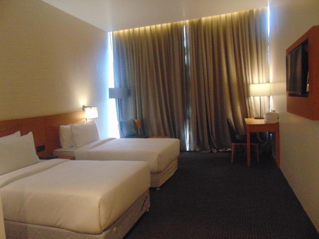 a hotel room with two beds and a window at The Vern at BLVD in Nashik