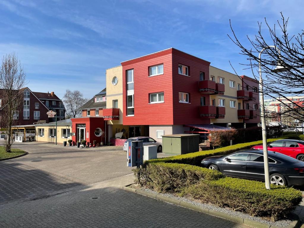 un edificio rojo al lado de una calle en Hotel Neptun en Schillig