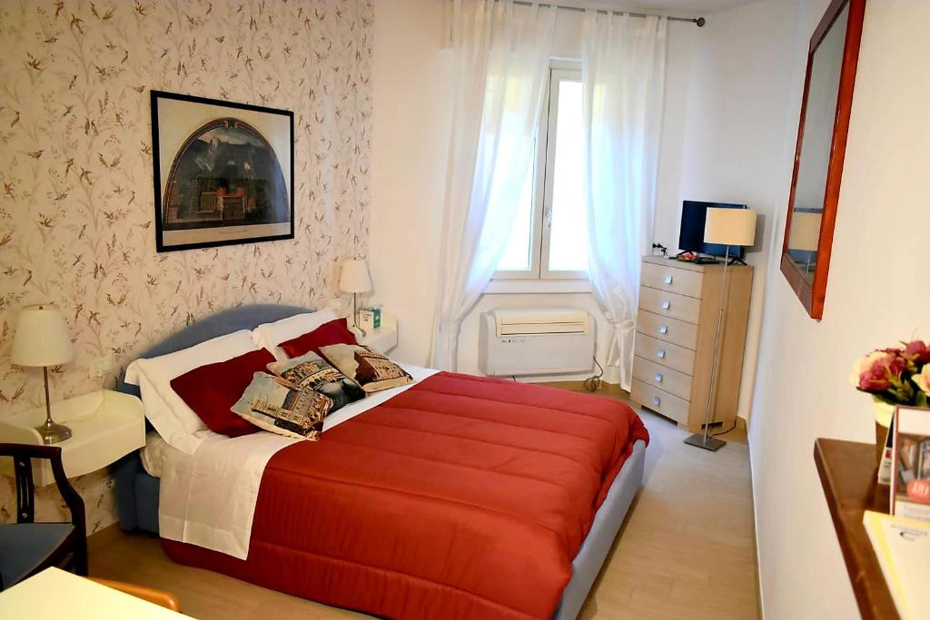 een slaapkamer met een rood bed en een raam bij appartamento pontevecchio in Florence