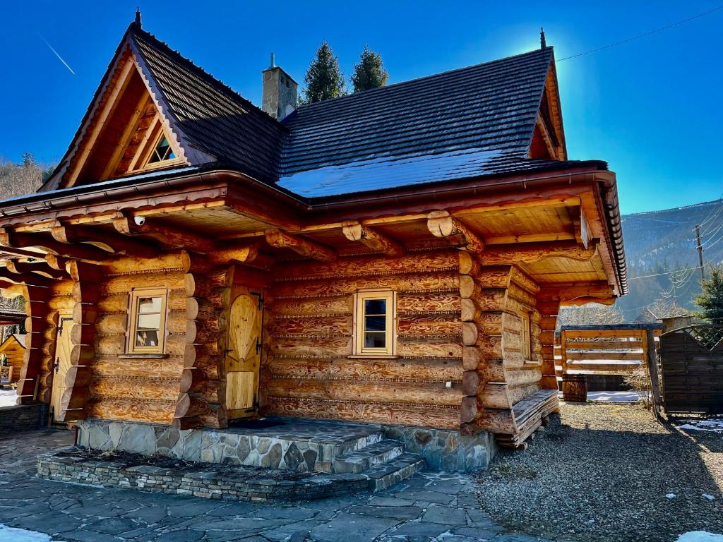 a log cabin with a black roof at Apartament Lis in Szczyrk