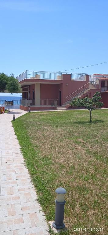 a pole in the grass in front of a building at lemonishouse by the sea 1 in Nea Skioni