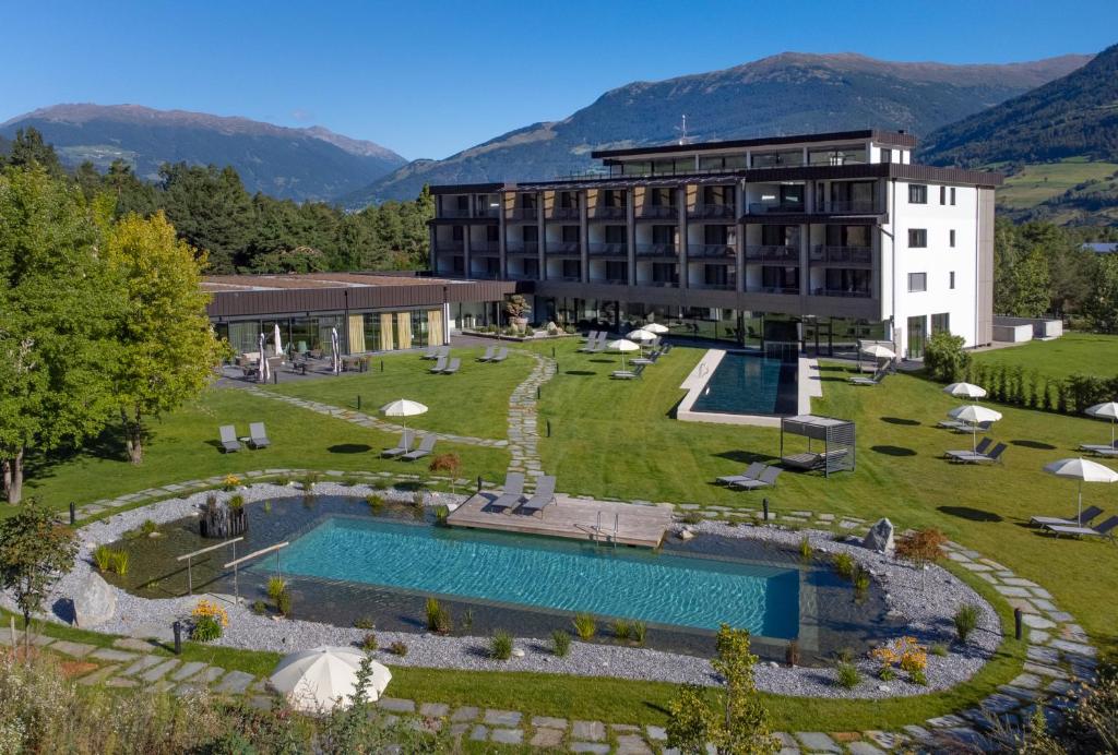 ein Resort mit einem großen Pool und einem Gebäude in der Unterkunft Garden Park Hotel in Prad am Stilfserjoch