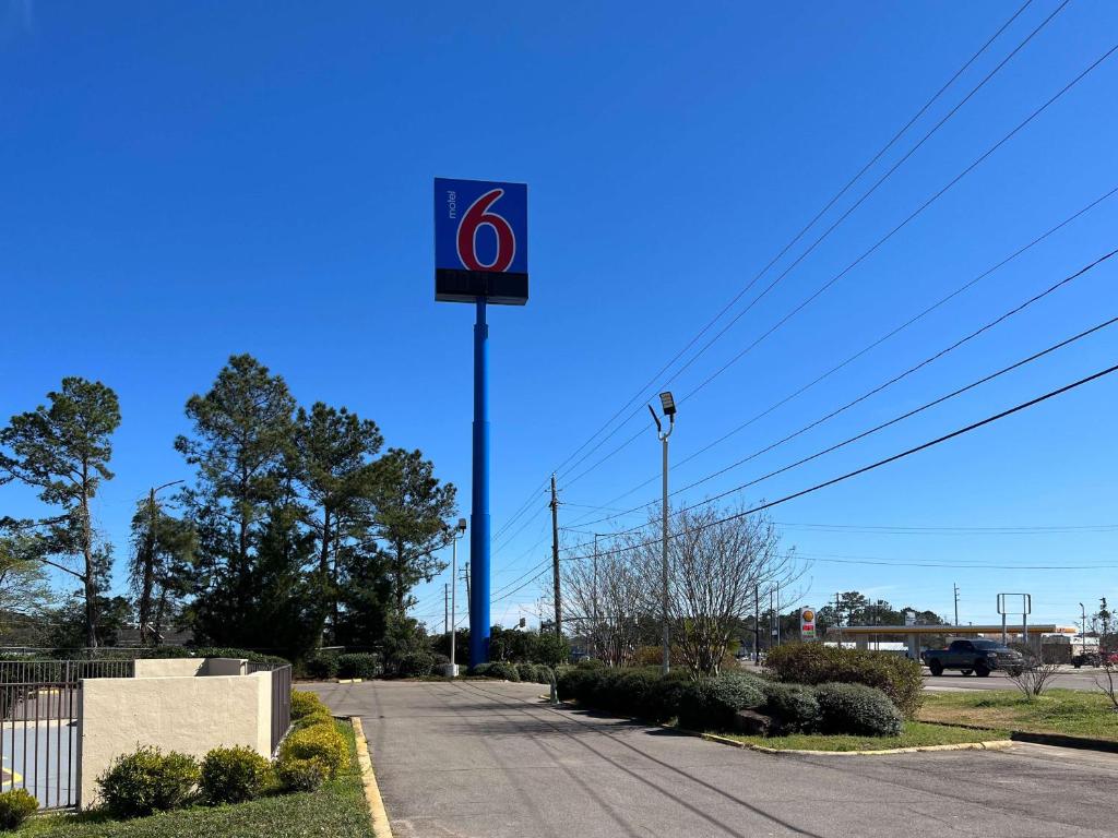 a sign on a pole in the middle of a road at Motel 6 Hattiesburg, MS in Hattiesburg